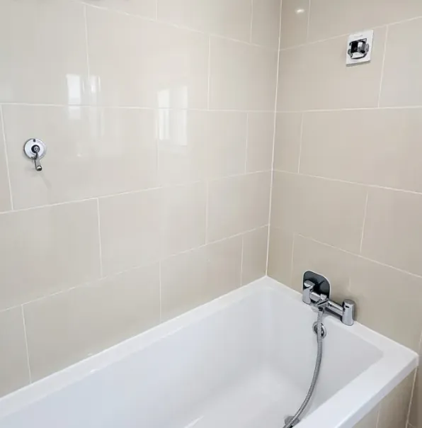 Bathroom tiles and bath after cleaning, white grout and no limescale